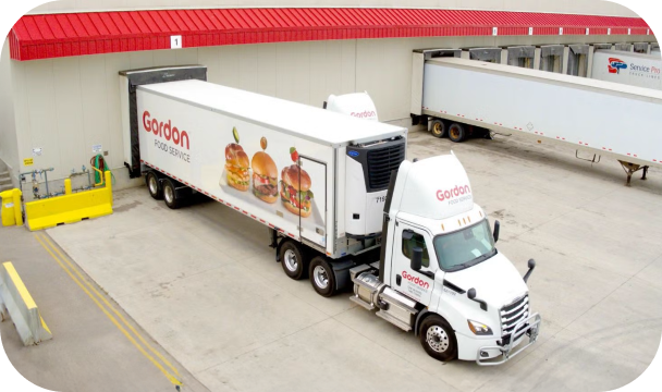 En Gordon Food Service-lastebil parkert foran et lager.