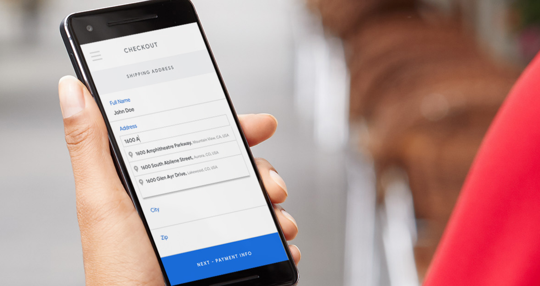 Hand holding phone displaying a checkout screen.