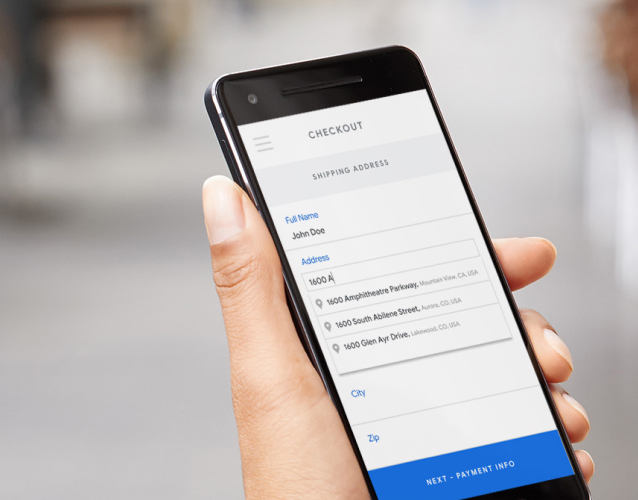 Hand holding phone displaying a checkout screen.